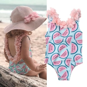 Einteiliger Badeanzug für Mädchen mit Wassermelonen-Print an einem Strand, im Sand, am Meer