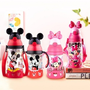 Trinkflasche in Form von Mickey Mouse für Kinder in Rot und Rosa auf einem Tisch mit weißer Wand