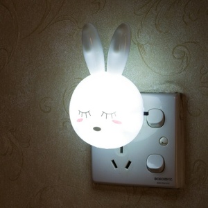 Wand-Nachttischlampe in Form eines Hasen in einer Wandsteckdose