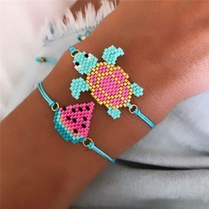 Boho-Armband mit Schildkröten- und Wassermelonenmotiv für ein türkisfarbenes Kind am Handgelenk einer Frau