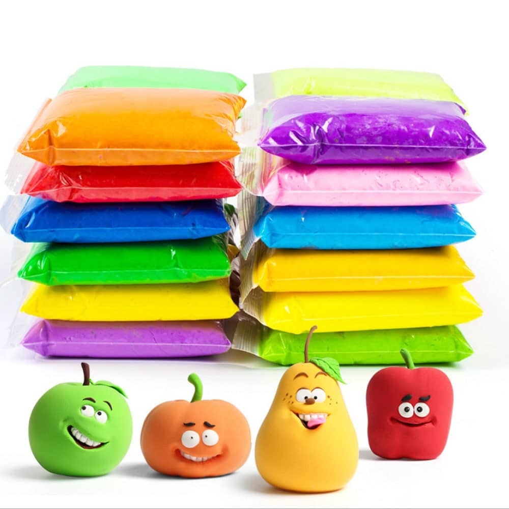 Superleichte 12-farbige Kinderknete mit Apfel, Orange, Banane und einer Erdbeere auf weißem Hintergrund