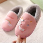 Rosa und graue Einhorn-Pantoffeln für Babys auf einem weißen Teppich