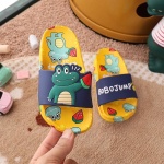 Krokodil-Flip-Flops für Kinder in Gelb und Blau mit harten Krokodilmotiven aus der Hand einer Person