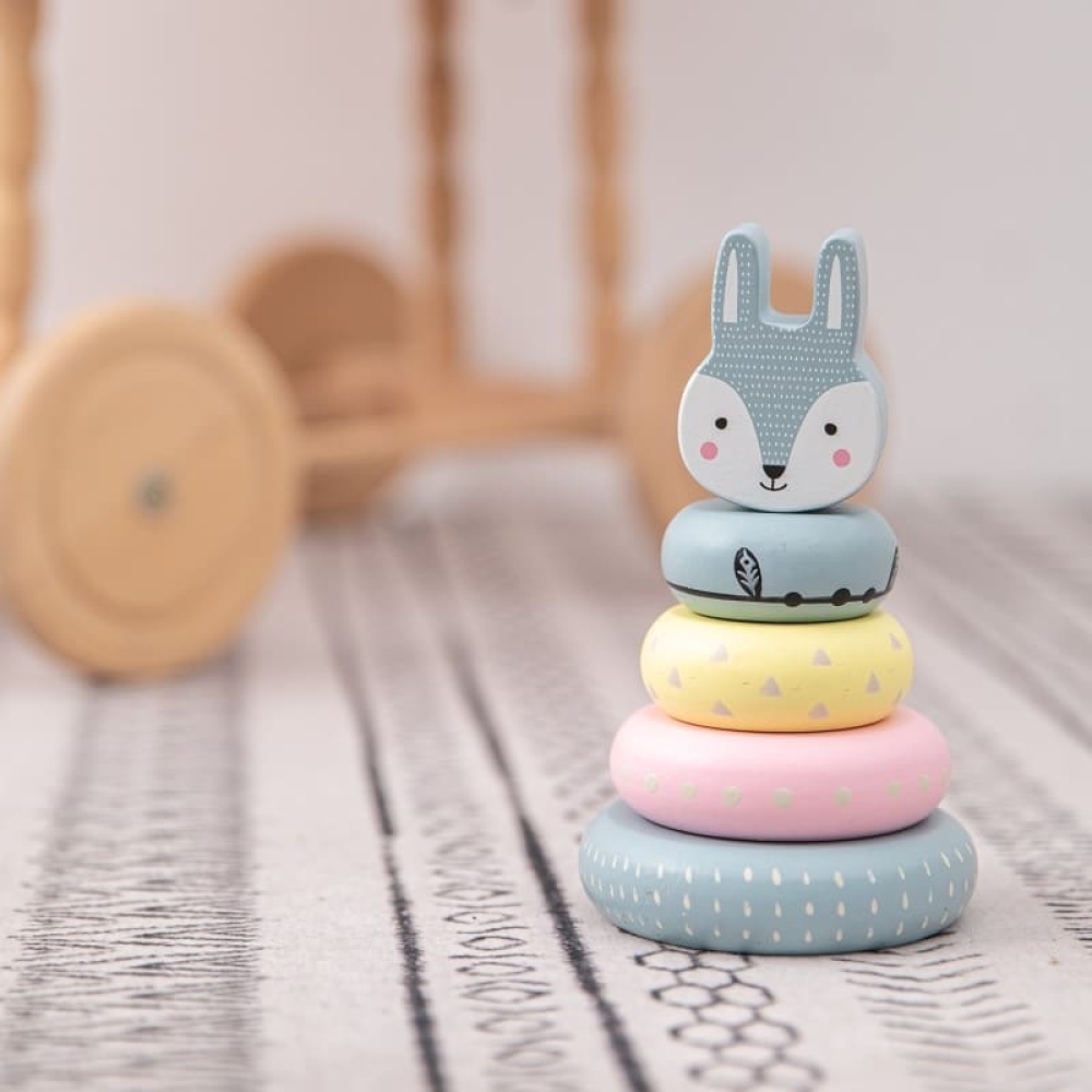 Holzspielzeug für Babys in Form eines Hasen auf einem Teppich
