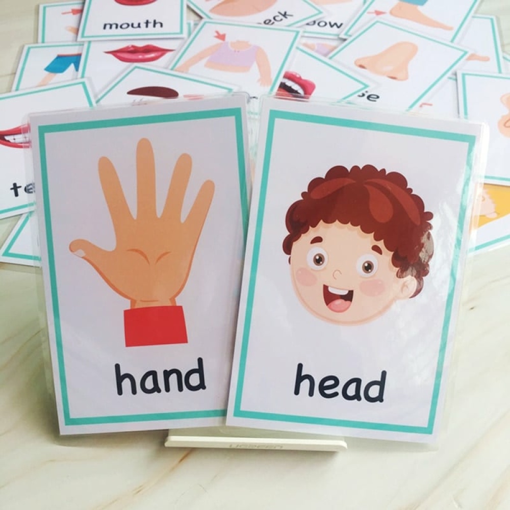 Kartenspiel für Babys mit Hand und Kopf und anderen Karten auf einem Bettchen