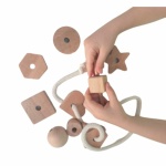 Kinderspiel mit geometrischen Formen aus Holz mit weißem Seil