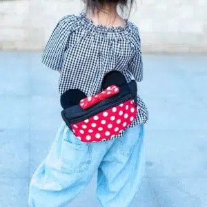 Gürteltasche mit Ohren von Mickey und Minnie in rot, schwarz und weiß auf dem Rücken eines Mädchens