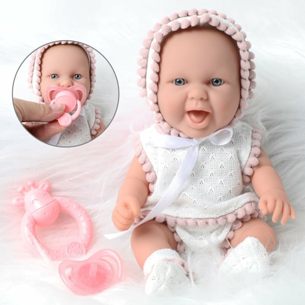 Puppe mit rosa und weißer Kleidung für Neugeborene auf einem weißen Mantel