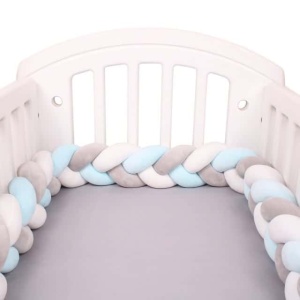 Geflochtener Bettumrandung weiß grau blau in einem weißen Babybett mit grauer Bettwäsche