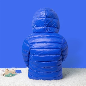 Mehrfarbige Daunenjacke für Kinder in Blau auf einem weißen Teppich