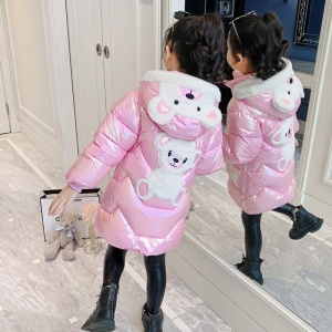 Lange Bärenjacke mit glänzender Kapuze für Mädchen in Rosa mit Bären in der Kapuze und auf dem Rücken eines Mädchens vor einem Spiegel