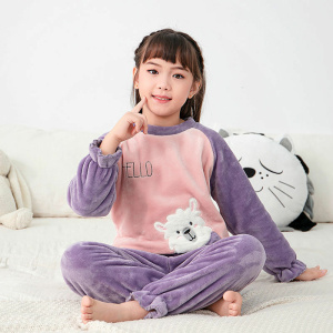 Fleece-Pyjama aus Flanell mit einem niedlichen Muster für Kinder in lila und rosa über ein Mädchen in einem weißen Teppich mit einem Kissen hinten