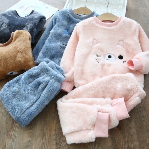 Warmes Fleece-Pyjama-Set mit Katzenmotiv für Kinder in Rosa und Blau auf einem Holztisch