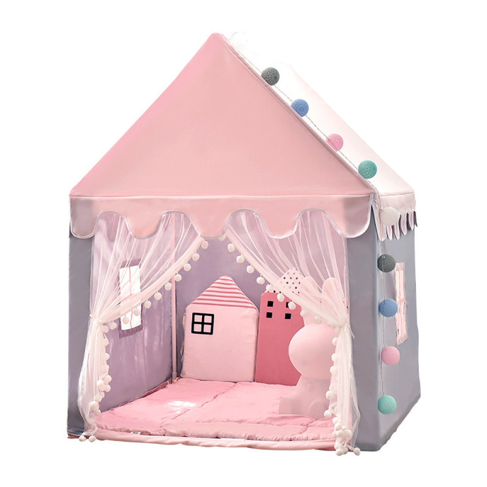 Ein Tipi für Kinder in Form eines rosafarbenen Häuschens. Die Vorderseite ist offen mit zwei Vorhängen, die an den Seiten aufgehängt sind. An den Seiten befinden sich kleine Fenster. Im Inneren gibt es einen rosafarbenen gepolsterten Boden und rosafarbene Kissen.
