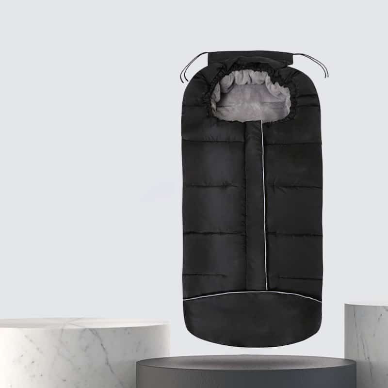 Ein schwarzer Kinderschlafsack mit zwei Schnüren, mit denen er am Kopf geschlossen werden kann. Die Innenfarbe ist dunkelgrau.