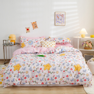 Schlafzimmer mit einem Bett in der Mitte, einer rosa gemusterten Bettdecke und Dekorationselementen