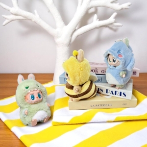 Tierkostüme für Labubu Plüschfigur: Biene, Dinosaurier und Fisch, flach auf einer Oberfläche ausgebreitet.