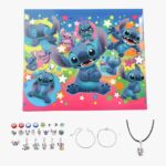 Adventskalender Stitch Schmuckherstellung. Unter dem Kalender, Stitch Anhänger, zwei silberne Armbänder und eine Halskette mit schwarzer Kordel. Auf weißem Hintergrund.