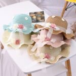 Chapeau d'été pour les bébés disposés sur une table, on peut voir toutes les couleurs disponibles.